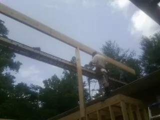 Carpenter setting a ridge beam over a new addition frame — Ice Dam Removal by Roofing Brothers in Walnut