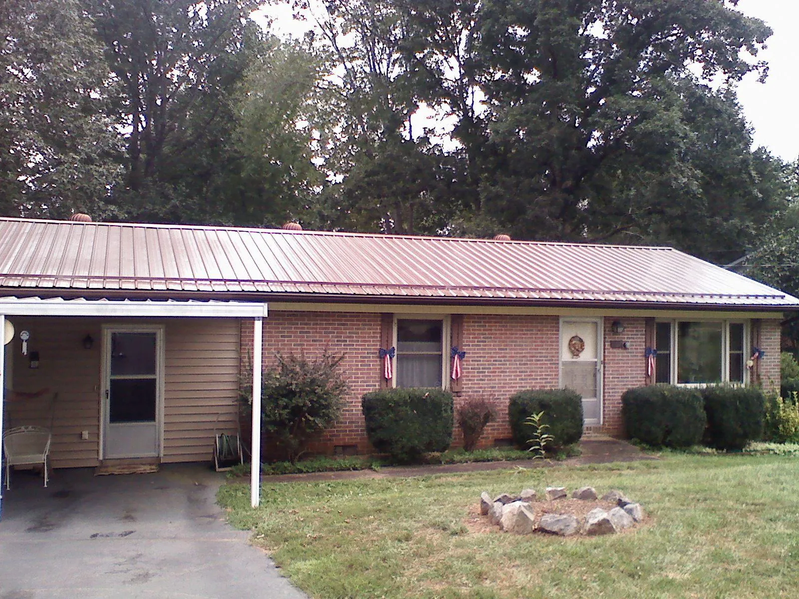 Bronze metal roof and carport on a brick ranch home — Roof Repair work by our crew in Walnut